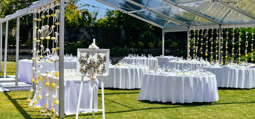 round tables, place settings and chairs set up outside for a wedding